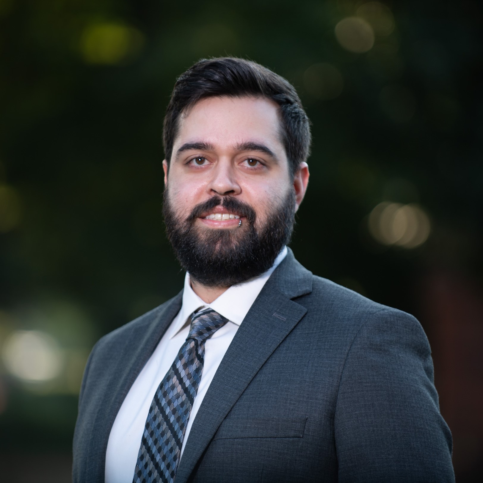 Smiling man with black hair and beard