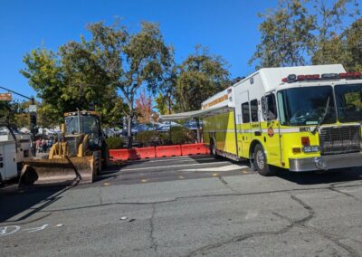 Hazmat vehicle alongside a tractor at a festival.